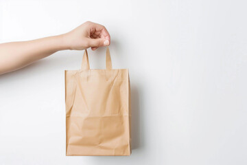 Hand holding a recyclable paper bag isolated on a white background