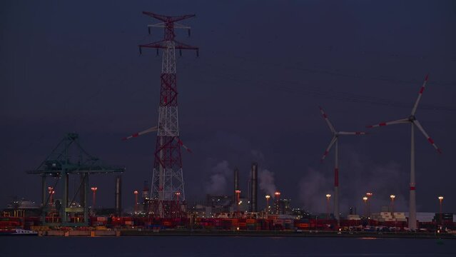 Container terminal showing wharf with electricity pylon, gantry crane / portainer crane along the Western Scheldt in Antwerp port, Flanders, Belgium