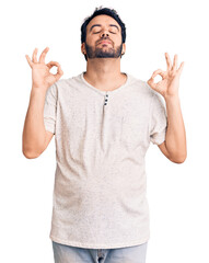 Young hispanic man wearing casual clothes relax and smiling with eyes closed doing meditation gesture with fingers. yoga concept.