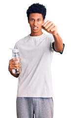 Young african american man wearing sportswear holding water bottle annoyed and frustrated shouting with anger, yelling crazy with anger and hand raised - obrazy, fototapety, plakaty