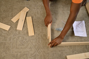 A guy is trying to assemble a rack without instructions, top view