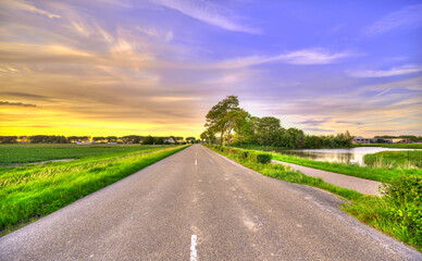 Country road in pastoral Holland at sunset. - obrazy, fototapety, plakaty