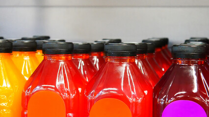 Close-up of many colorful bottles of different juices on a store shelf