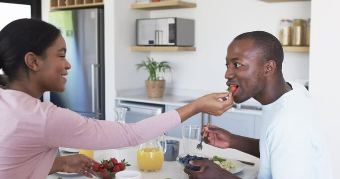A diverse couple enjoys a breakfast together at home