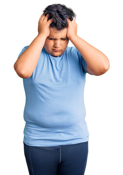 Little boy kid wearing sports workout clothes suffering from headache desperate and stressed because pain and migraine. hands on head.