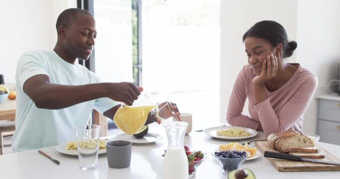 African American couple enjoys breakfast together at home in the kitchen