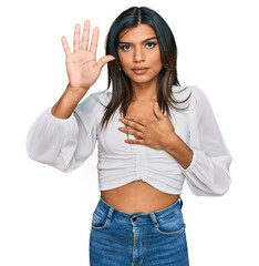 Young latin transsexual transgender woman wearing casual clothes swearing with hand on chest and...