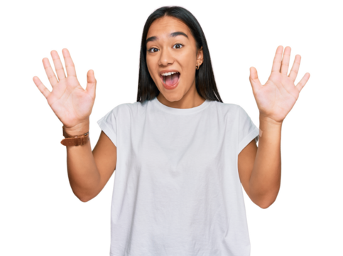 Young asian woman wearing casual white t shirt showing and pointing up with fingers number ten while smiling confident and happy.