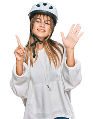 Teenager caucasian girl wearing bike helmet showing and pointing up with fingers number six while smiling confident and happy.