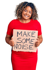 Young african american plus size woman holding make some noise banner looking positive and happy standing and smiling with a confident smile showing teeth