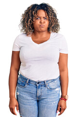 Young african american plus size woman wearing casual clothes puffing cheeks with funny face. mouth inflated with air, crazy expression.