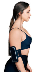 Young hispanic woman wearing sportswear looking to side, relax profile pose with natural face with...
