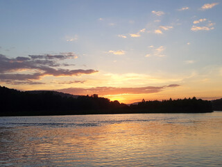 Sunset over the forest river. Beautiful sunset over river. River at sunset. Sunset river water