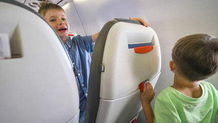Restless cheerful siblings enjoy travel by airplane