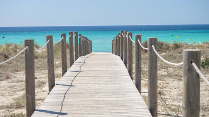 Fototapeta na wymiar Wooden pontoon to the Son Bou beach in Menorca, Spain