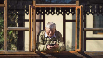 Elderly man with white hair having a phone video call with loved ones