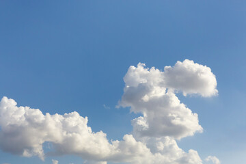 Fluffy cumulus clouds against a bright blue sky, minimalist design trending with clear color...