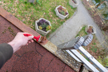 Verwittertes Holz am Dach an einer Leiter vom Gartenhaus nach dem Winter mit Holzschutzlasur...