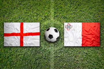 England and Malta flags on soccer field