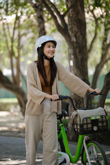 Fototapeta na wymiar Asian businesswoman go to work at office stand and smiling wear backpack with bicycle. Bike commuting, Commute on bike, Business commuter concept.