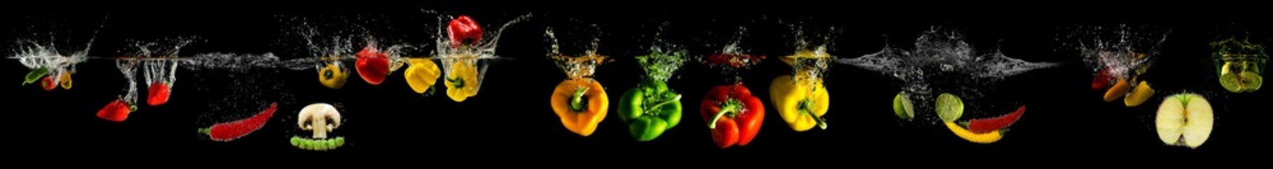 Vegetables falling into water on a black background