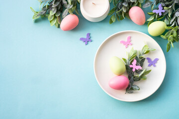 Easter table setting, Easter food background. White plate with eggs and holiday decorations. Top view with copy space.