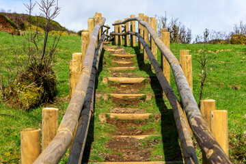 Wooden footbridge winding through sulfur fumaroles in Terceira Island's furnas, Azores. - obrazy, fototapety, plakaty