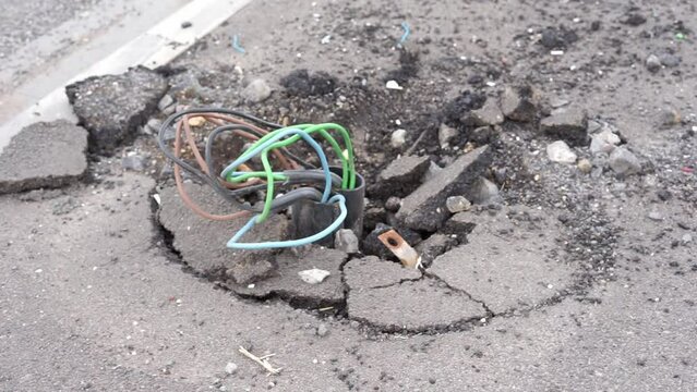 power line sticking out from the asphalt