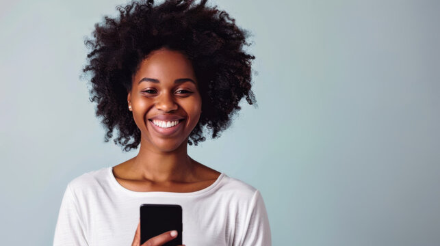 Smiling African American woman with natural hair using smartphone