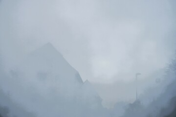 Abstraktes Motiv Häusern, Straßenlaterne und Himmel bei Nebel, Frost und Kälte am Morgen im Winter 
