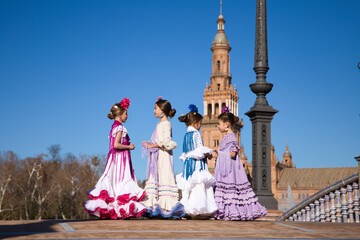 Four little girls dancing flamenco dressed in typical flamenco dress talk to each other in a famous...