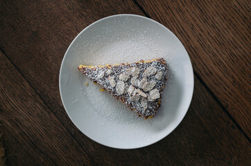 piece of almond orange cake with icing sugar on a plate