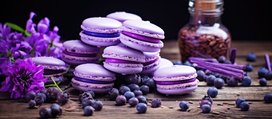 Obraz na płótnie Canvas A pile of vibrant purple macaroons arranged neatly on top of a rustic wooden table. The macaroons are perfectly baked and have a glossy finish, creating an enticing display.