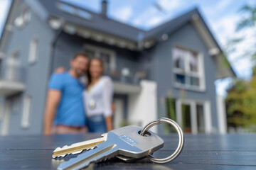 Man and woman dreaming of buying new house. Happy couple looking on keys of new home. Real estate purchasing