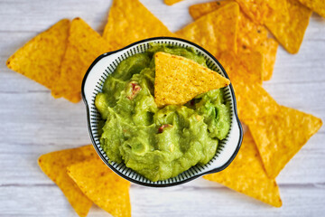 Avocado guacamole dip with tortilla nachos chips. Top view