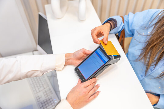 Woman paying with credit card in a beautician clinic