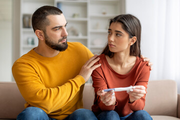 Concerned couple looking at a pregnancy test
