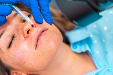 Woman receiving a botox injection to the lips