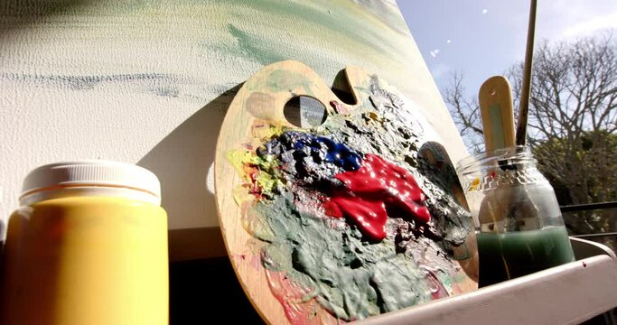 A palette and paints bask in sunlight