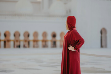Dubai,  Unite dArab Emirates - October 19, 2019 - A woman in a flowing red garment and headscarf...