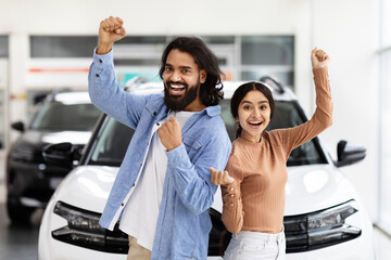 Excited hindu couple celebrating a new car purchase