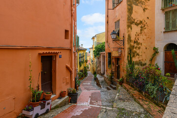 The narrow alleys and residential streets in the hilltop medieval Old Town at Menton, France, along the Cote d'Azur French Riviera. - obrazy, fototapety, plakaty