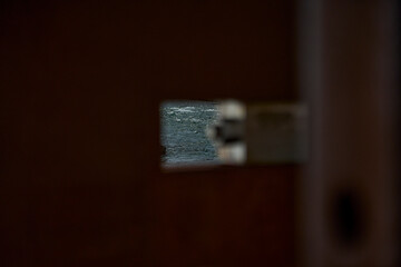 out of focus close up of details of a steel bolt and nut connection on a metal construction of a bridge at Trollstigen waterfalls in Norway with flowing water in the background.