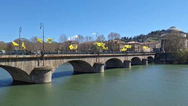 Turin, Piedmont, Italy - 03 24 2024: view of the Po river and the Umberto I bridge during a marathon with yellow flags waving in the wind