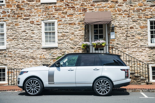 new british luxurious 4x4 SUV car Range Rover parked near the stone wall of a house in the ancient city.