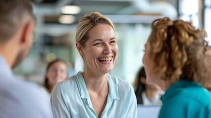 A woman is laughing joyfully during a meeting with colleagues.