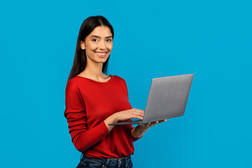 Woman In Red Shirt Holding Laptop Computer In Hands