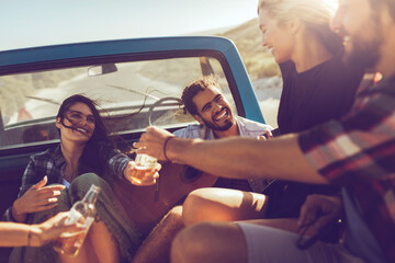 Friends enjoying a road trip with drinks and laughter