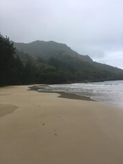 North Hawaiian sandy beach with mountain in the distance on a cloudy day
