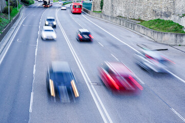 Abstract car traffic on a wide four-lane city street with blurred cars